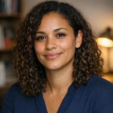 Woman in her early thirties with loose brown curls and medium-light skin, soft expressi…